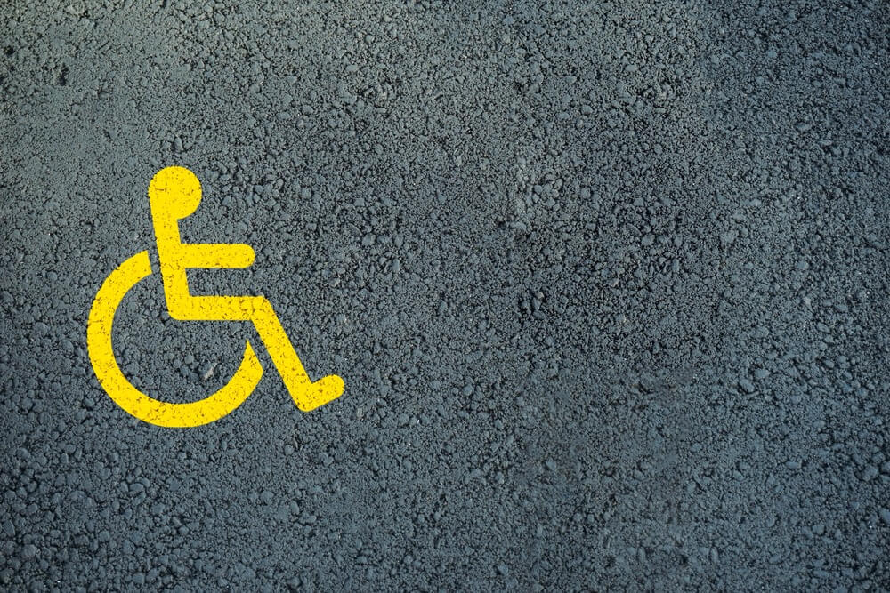 o que significa acessibilidade- fundo esverdeado com o símbolo internacional de acessibilidade em amarelo posicionado ao lado esquerdo da imagem.